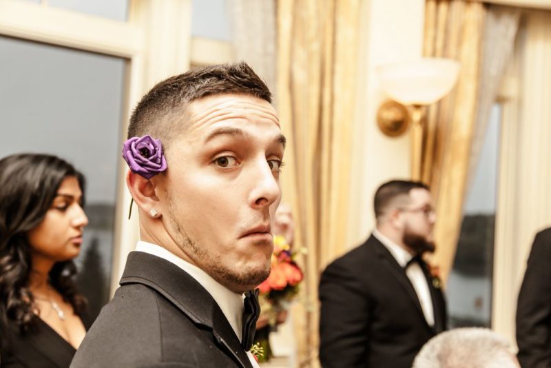 One of the two lives of the party - a best man trying to look his best with a flower behind his ear - Wentworth by the Sea - wedding photography