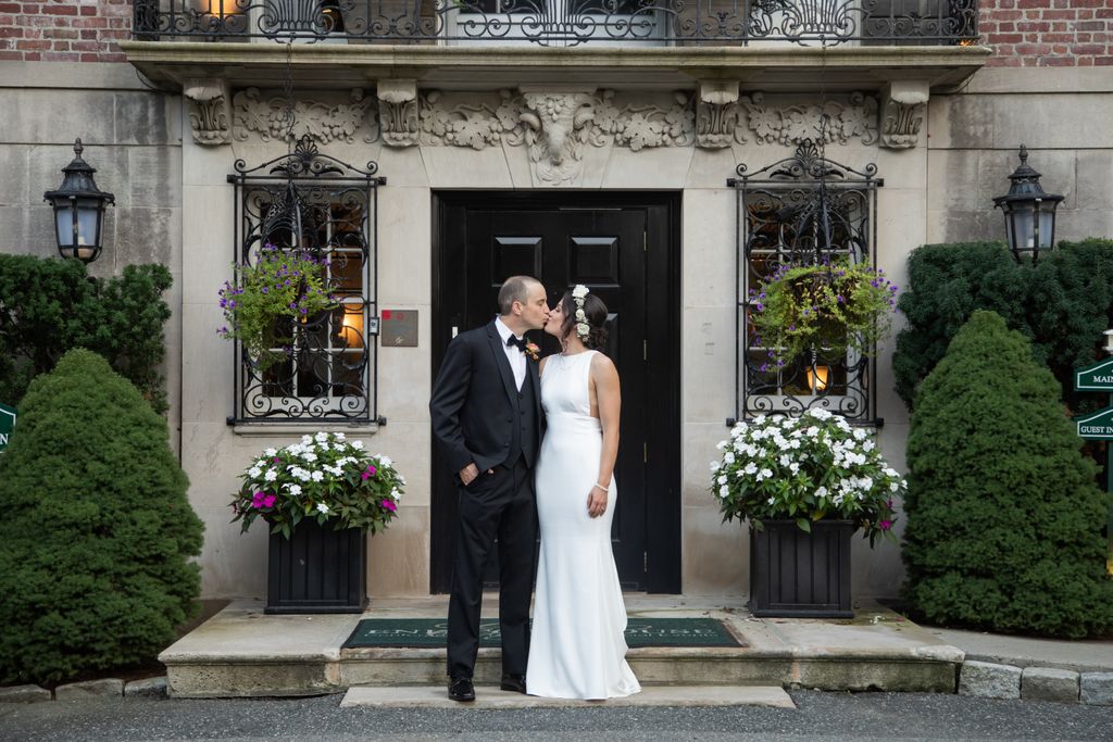Couple shares a kiss in front of the MIT Endicott House | Boston-area wedding photographer