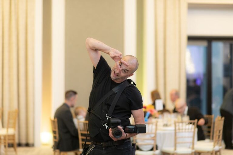 Aaron of Spagnolo Photography is photographed making a funny gesture on the dancefloor of the the Langham ballroom in Boston, during a wedding the Spagnolo Photography team covered there.