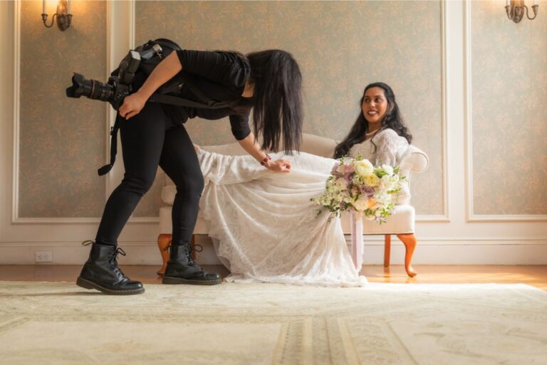 Nanore of Spagnolo Photography adjusts a bride's dress during a portrait session at an Endicott Estate wedding in Dedham, MA - the image is featured on the photographers' "About Us" page.
