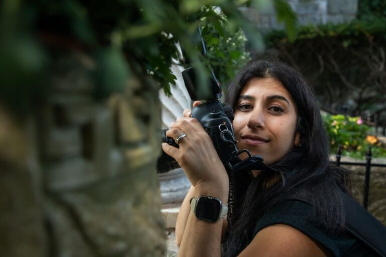 A photograph of Nanore of Spagnolo Photographyshooting a couple's first look from behind a wall at a Hammond Castle wedding in Gloucester, MA.