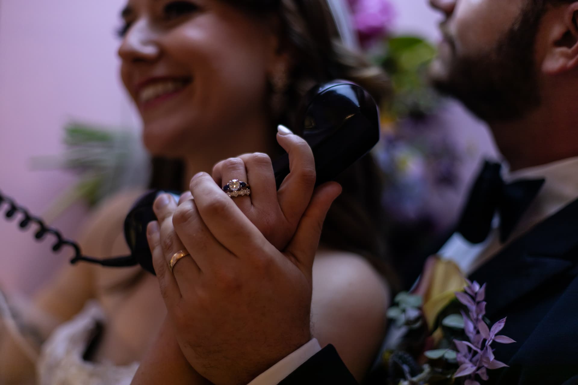 Wedding rings on a couple's hands holding a vintage telephone, photographed by creative Boston wedding photographers Spagnolo Photography.