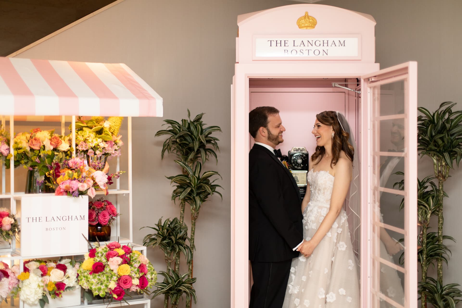 A couple shares a moment inside the Langham Boston’s pink phone booth, photographed by Spagnolo Photography.