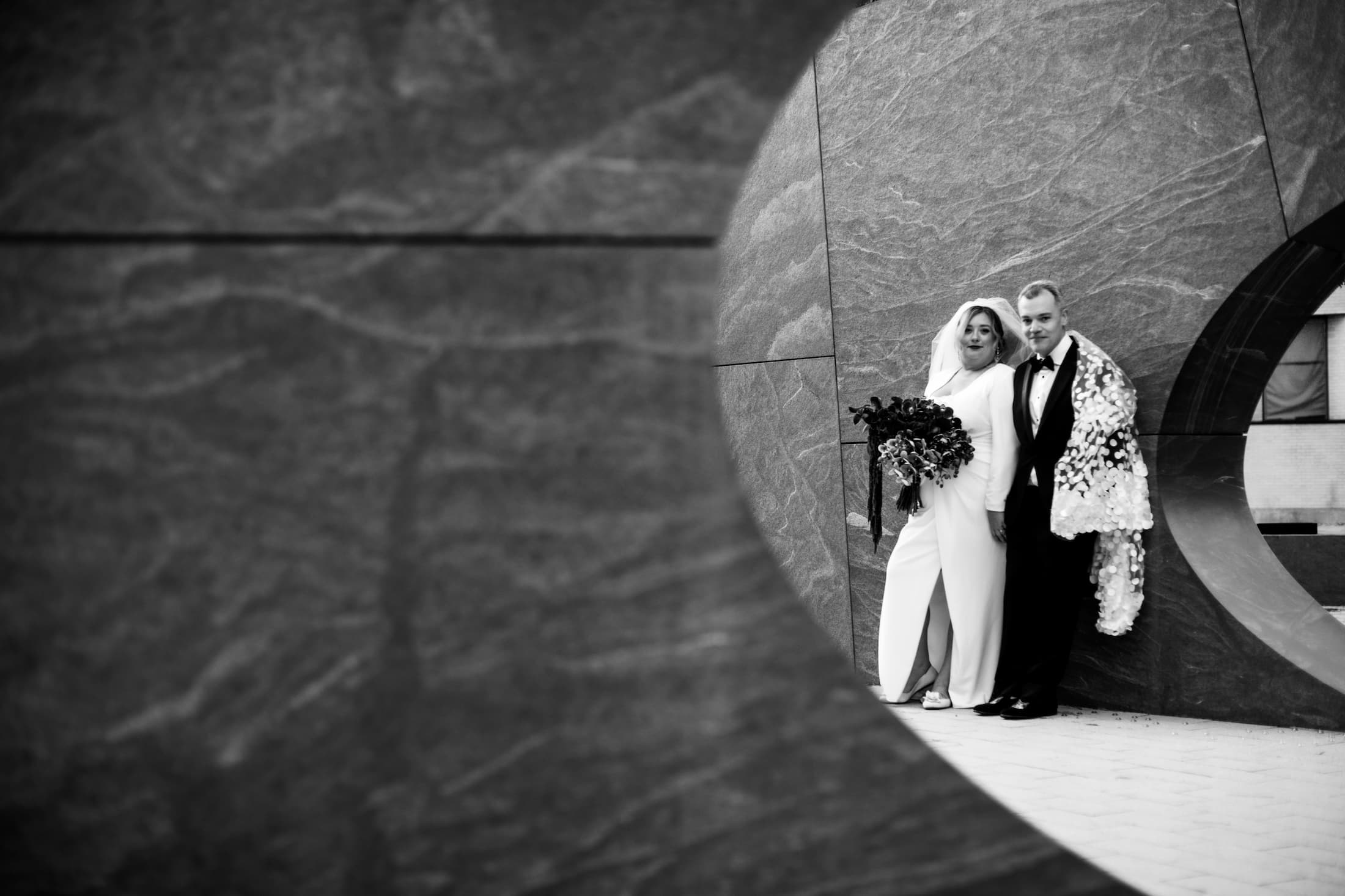 A black and white photograph of a bride and a groom at J. Meejin Yoon’s Sean Collier Memorial sculpture at MIT in Cambridge, Ma, photographed by Boston micro-wedding photographers Spagnolo Photography