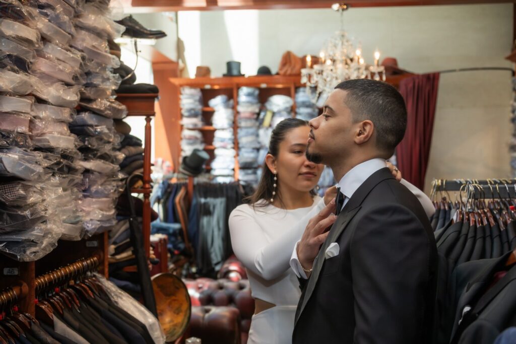 Groom getting fitted for a bow tie at Cuffs & Collars by Antoine Rubini in Boston on their way to City Hall to get married