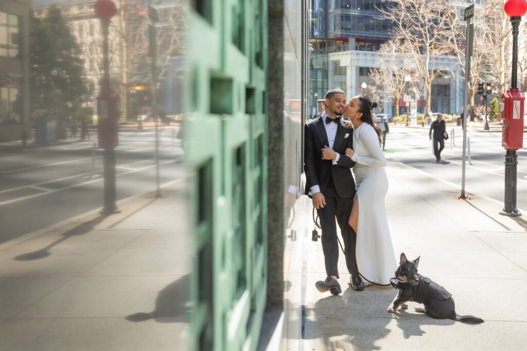 Boston City Hall wedding photographers capturing a portrait of the bride and groom posing with their dog on their walk to Boston City Hall for their wedding