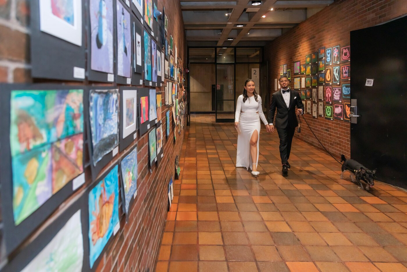 Bride and groom walking down a hallway at Boston City Hall where they will get married