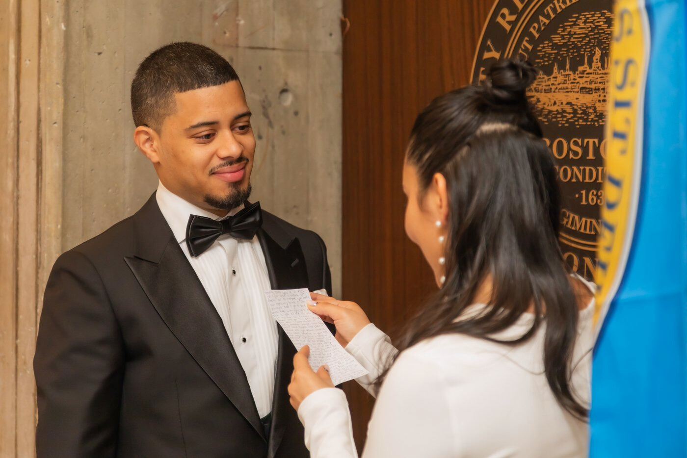 The groom looking at the bride lovingly as she reads her vows at Boston City Hall wedding