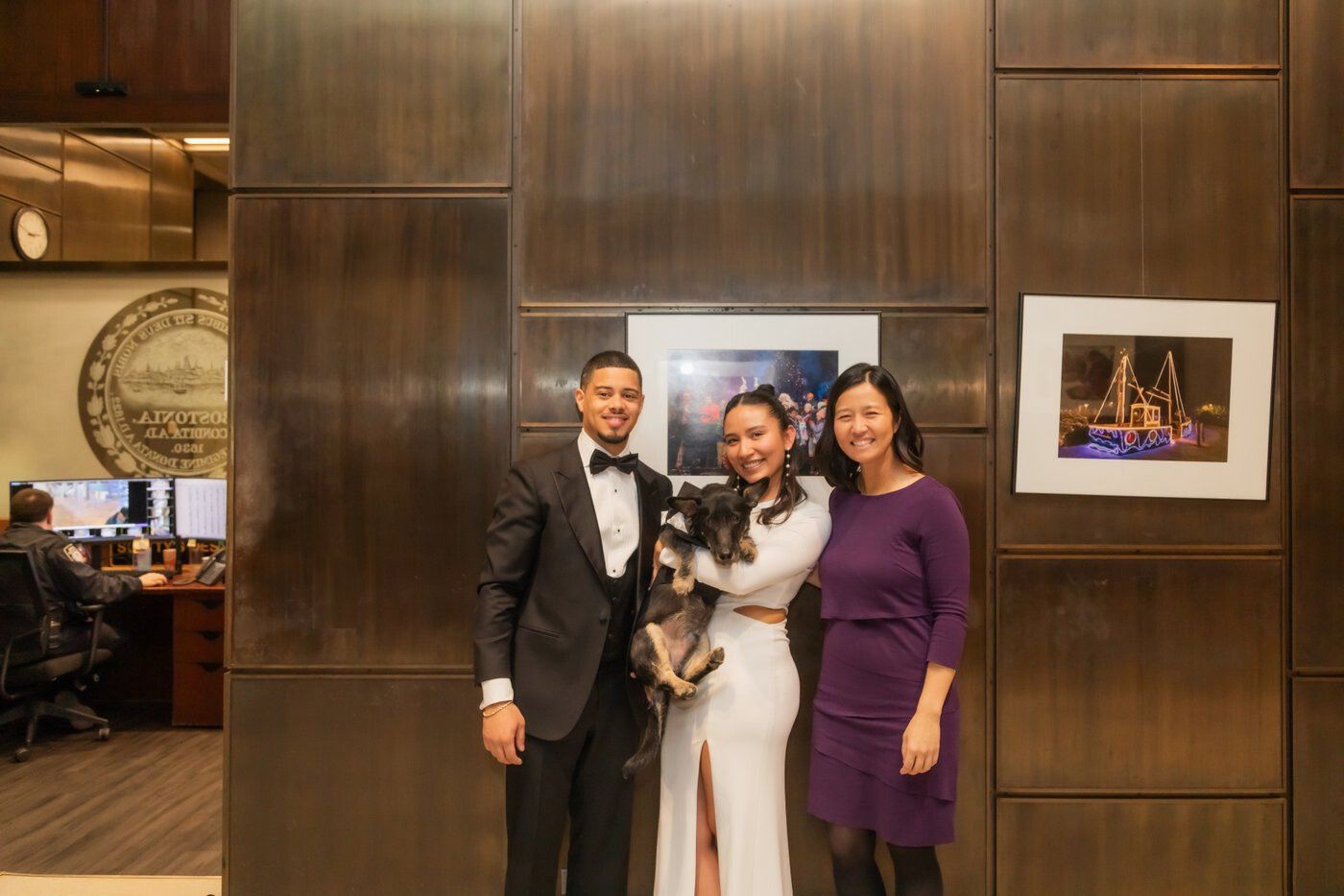 Mayor Michelle Wu posing with a newlywed couple and their dog in a tuxedo who served as witness during a Boston City Hall wedding elopement ceremony