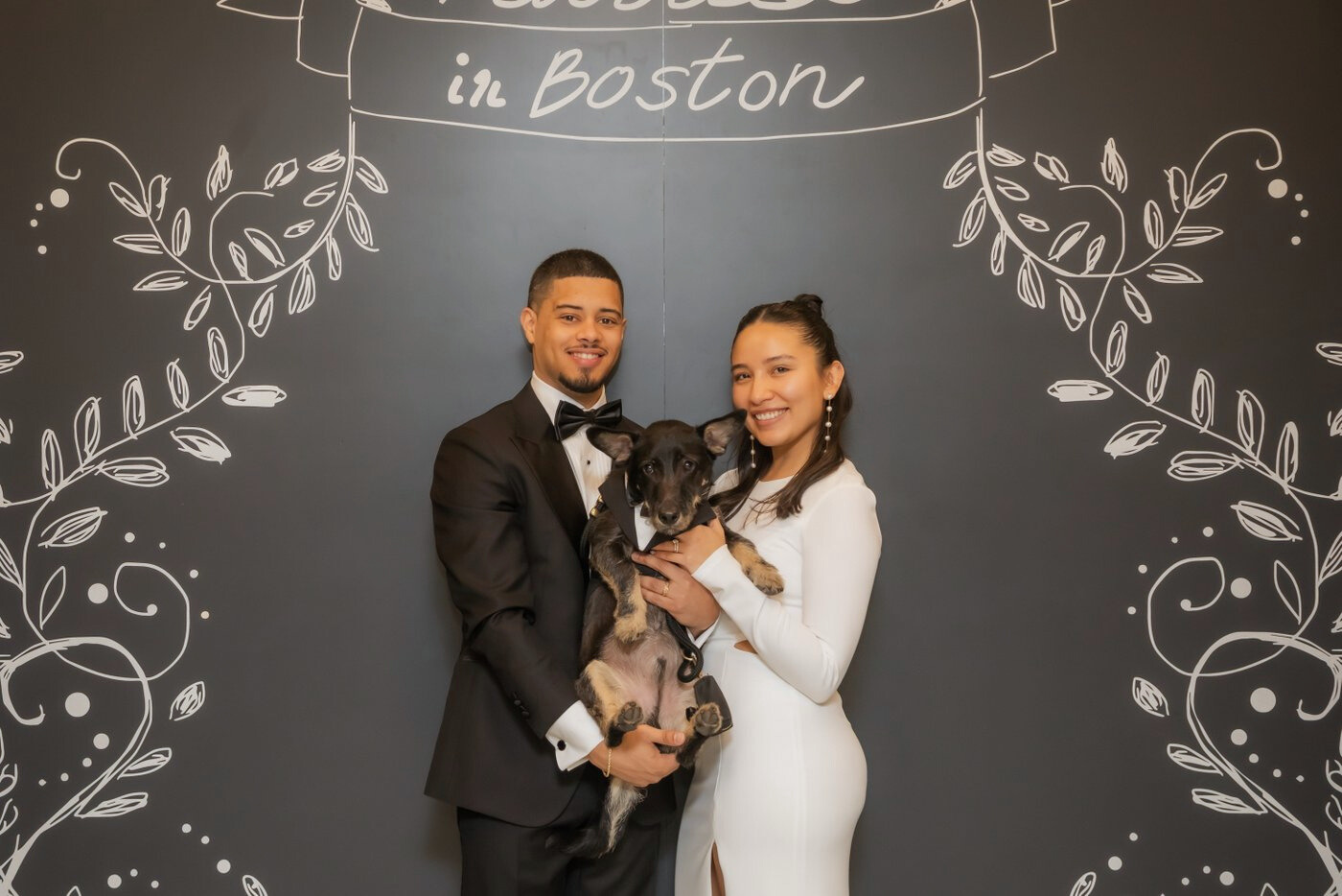 Boston City Hall wedding photographers Spagnolo Photography capturing a bride, a groom, and their dog under the "Married in Boston" sign following their Boston City Hall elopement.