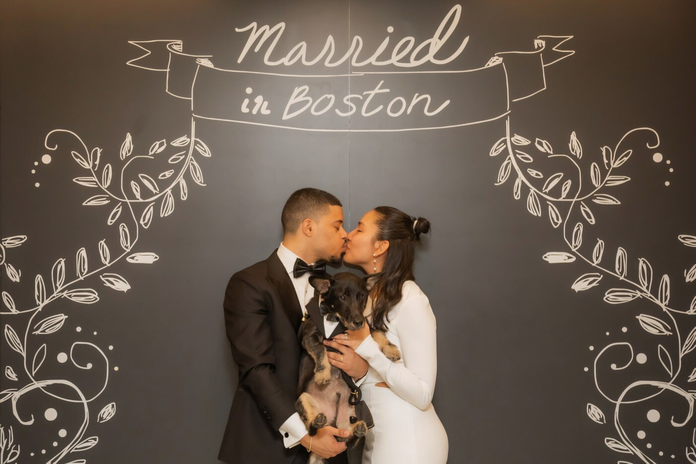 Boston City Hall wedding photographers Spagnolo Photography capturing a bride and a groom kissing under the "Married in Boston" sign following their Boston City Hall elopement.