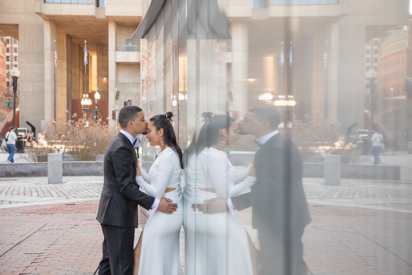 A groom kissing his bride's forehead after their Boston City Hall elopement