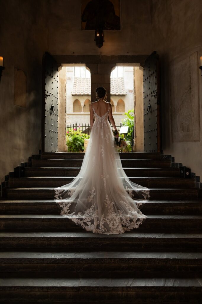 An ethereal shot of the bride on the stairs at Hammond Castle on her wedding day