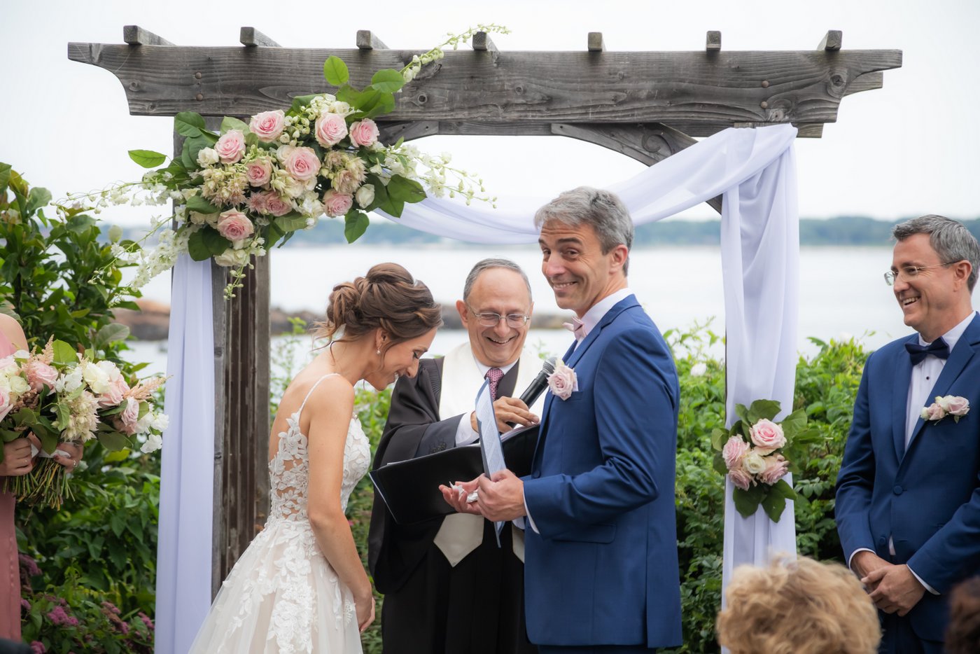 The groom grins at the camera during their Hammond Castle wedding ceremony