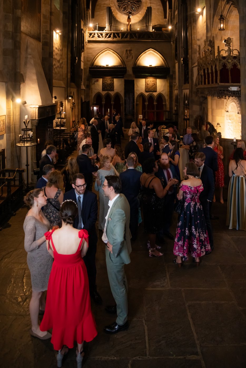 Guests talk in groups during cocktail hour at a Gloucester castle wedding