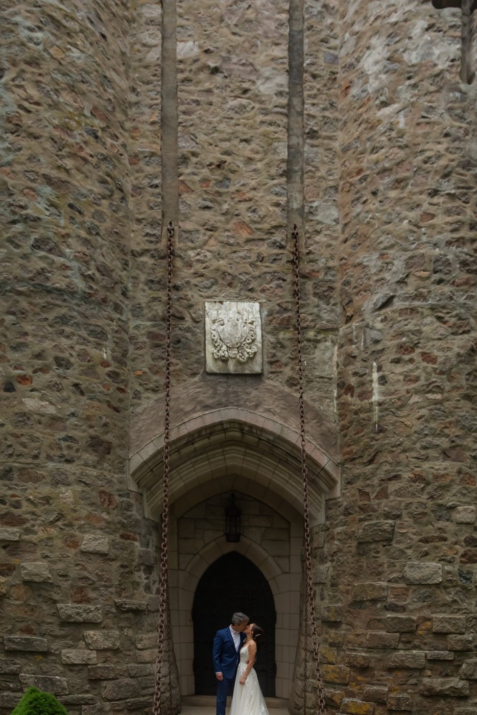 A wider shot of the couple on the Hammond Castle drawbridge before their grand entrance into the wedding reception tent