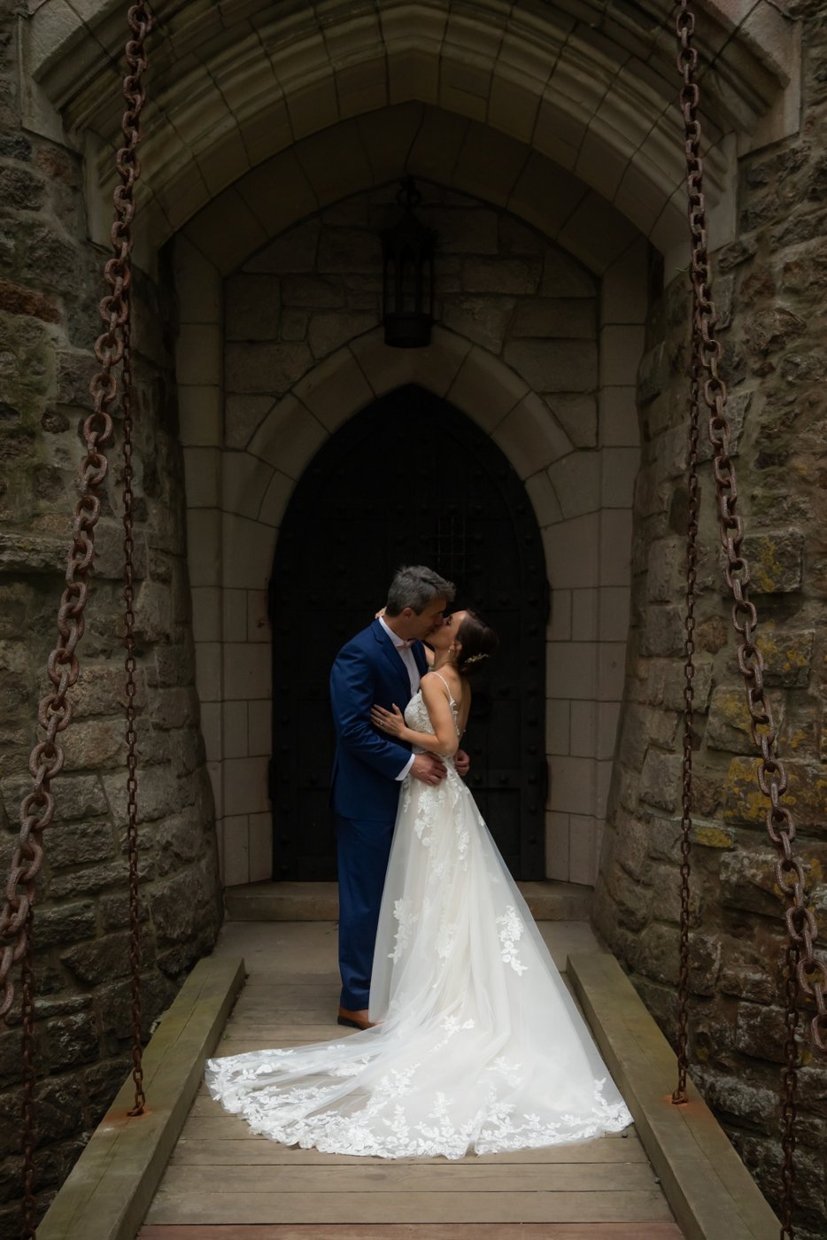 The bride and groom kiss on the Hammond Castle drawbridge before their grand entrance into the wedding reception tent