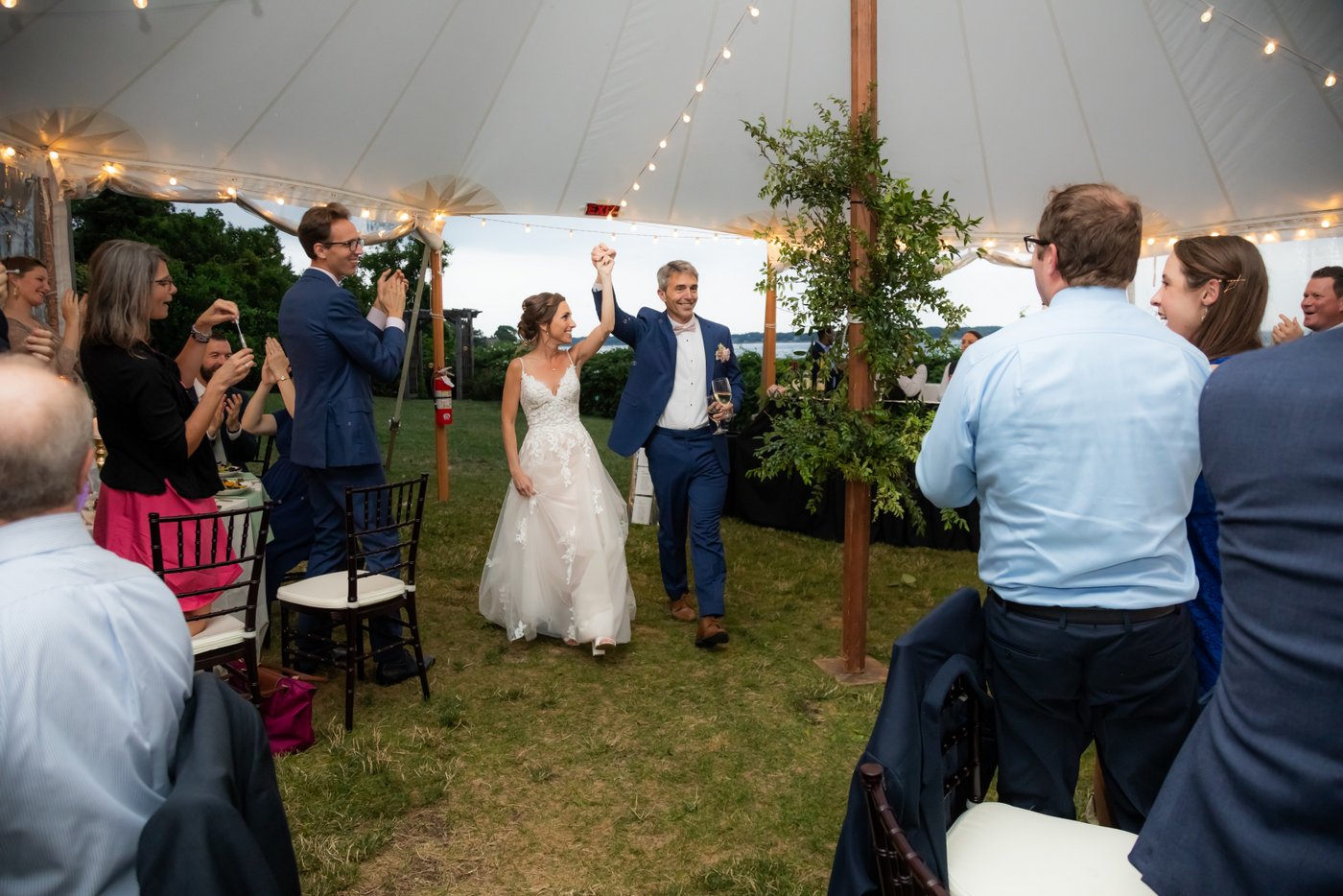 The bride and groom make their grand entrance into the wedding reception tent at Hammond Castle