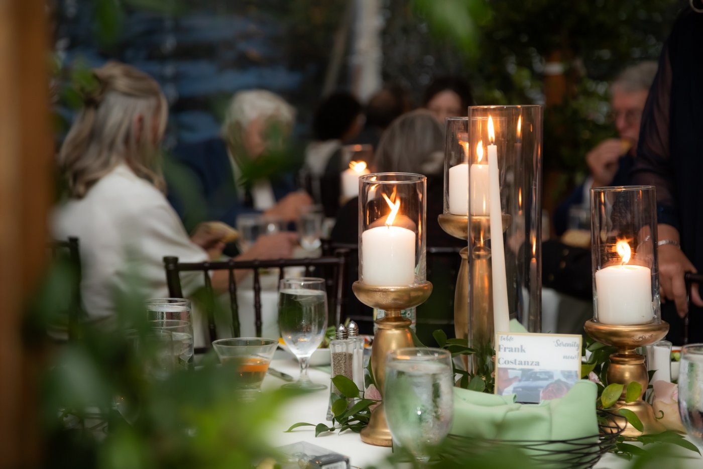Candles glow on the tables inside the wedding reception tent at Hammond Castle