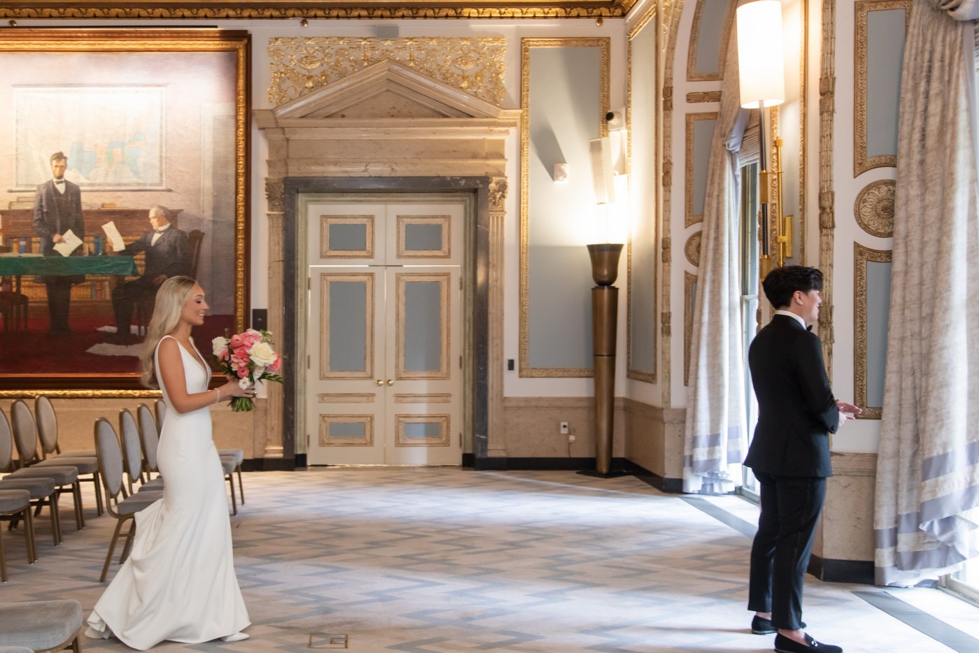 The bride walks up behind the groom for their first look in the Wyeth Room at the Langham Hotel in Boston
