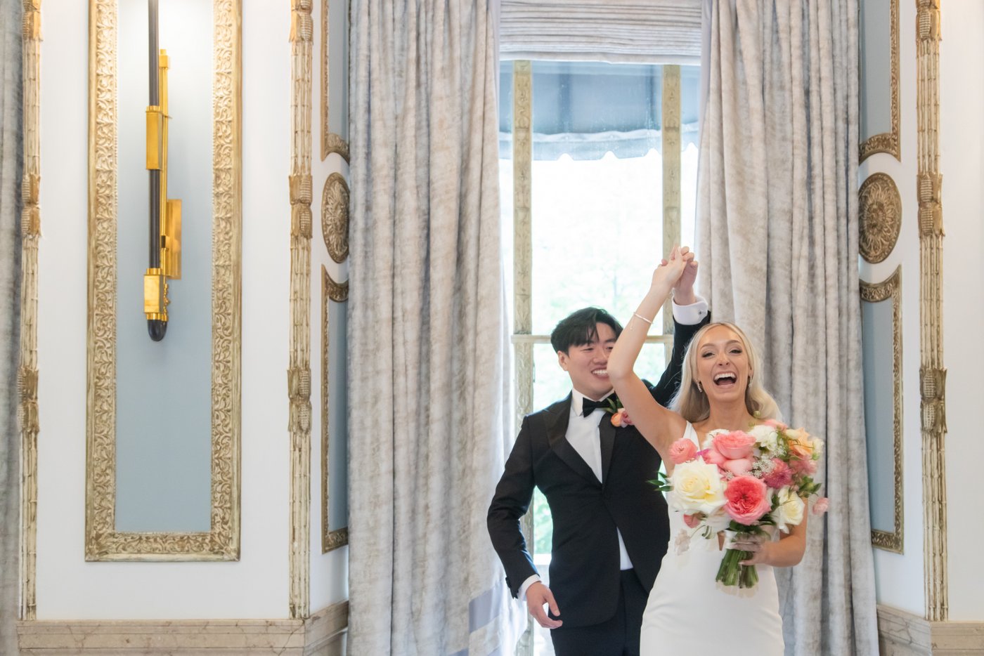 The groom twirls the bride during their first look at the Langham Hotel in Boston.