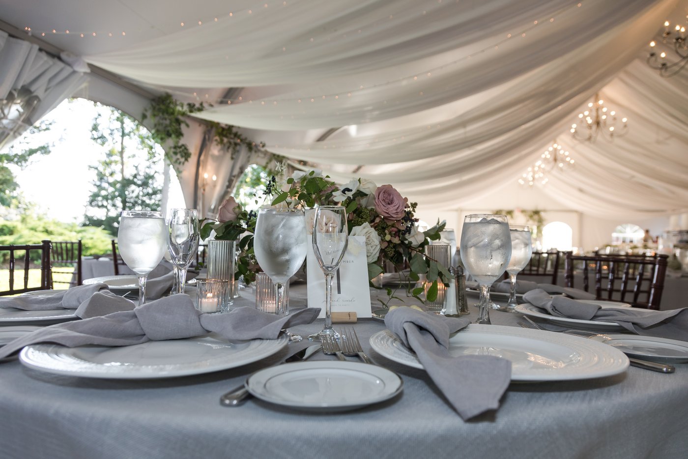 Tented Misselwood Estate wedding reception with pastel linens, candlelight, and seasonal florals