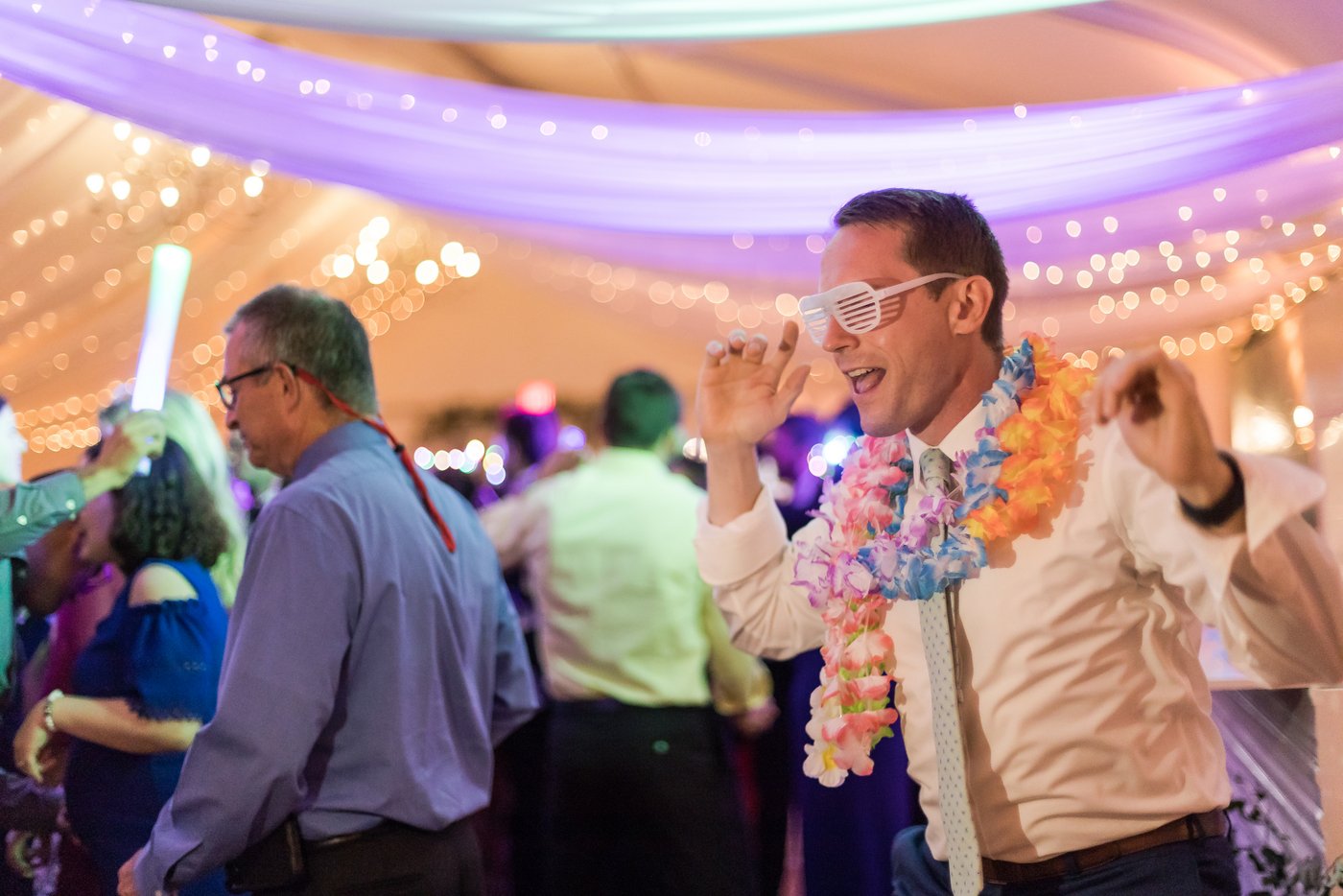 Guests dancing under string lights during La Hora Loca at tented Misselwood Estate wedding reception