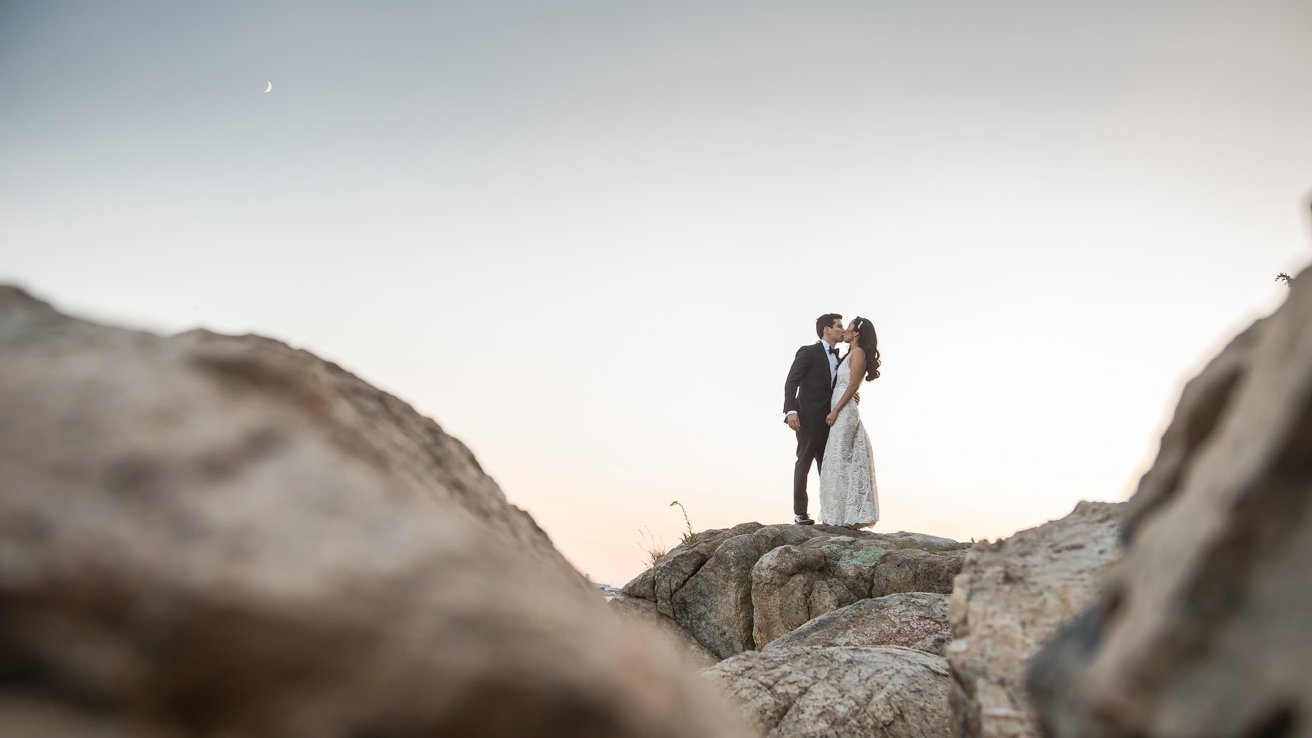 Bride and groom on the rocks at Misselwood Estate at sunset in Beverly MA