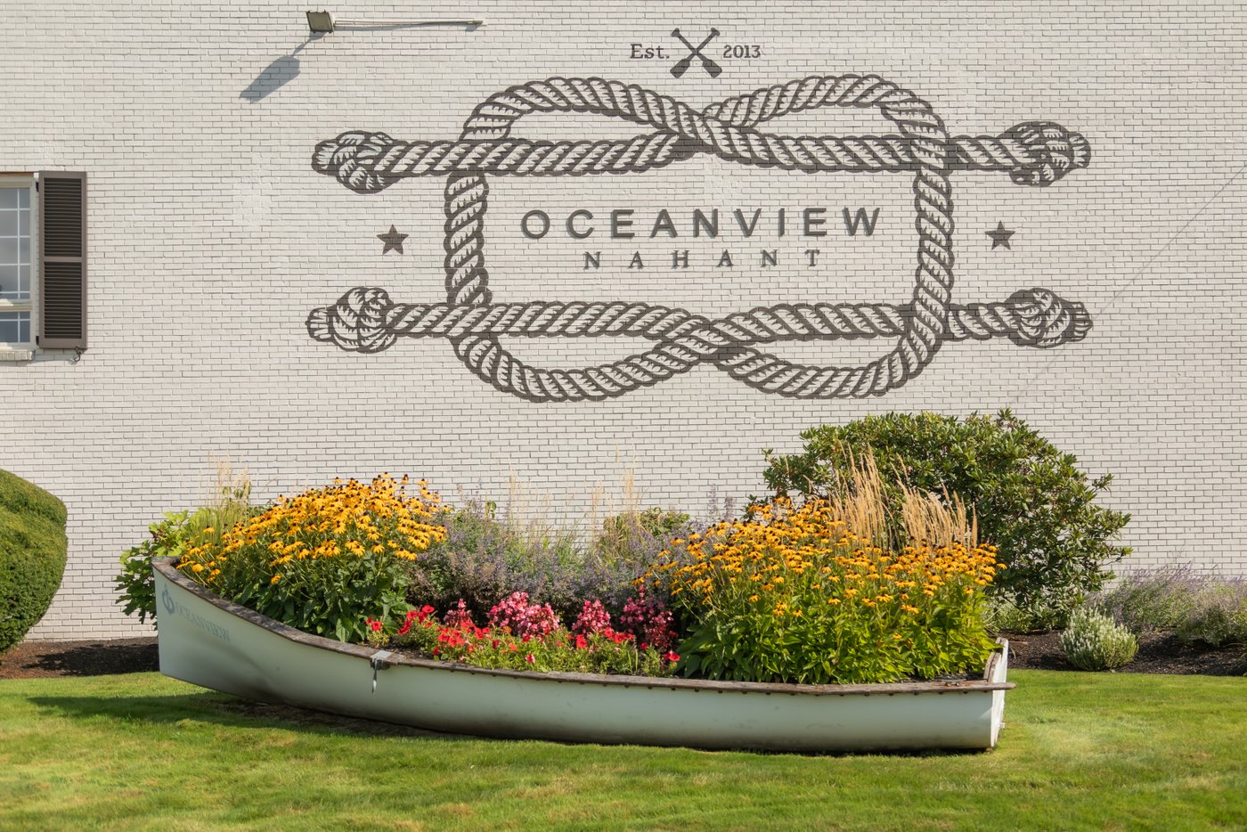 The front of Oceanview of Nahant with the decorative boat being used as a planter on Jessika and Michael's wedding day