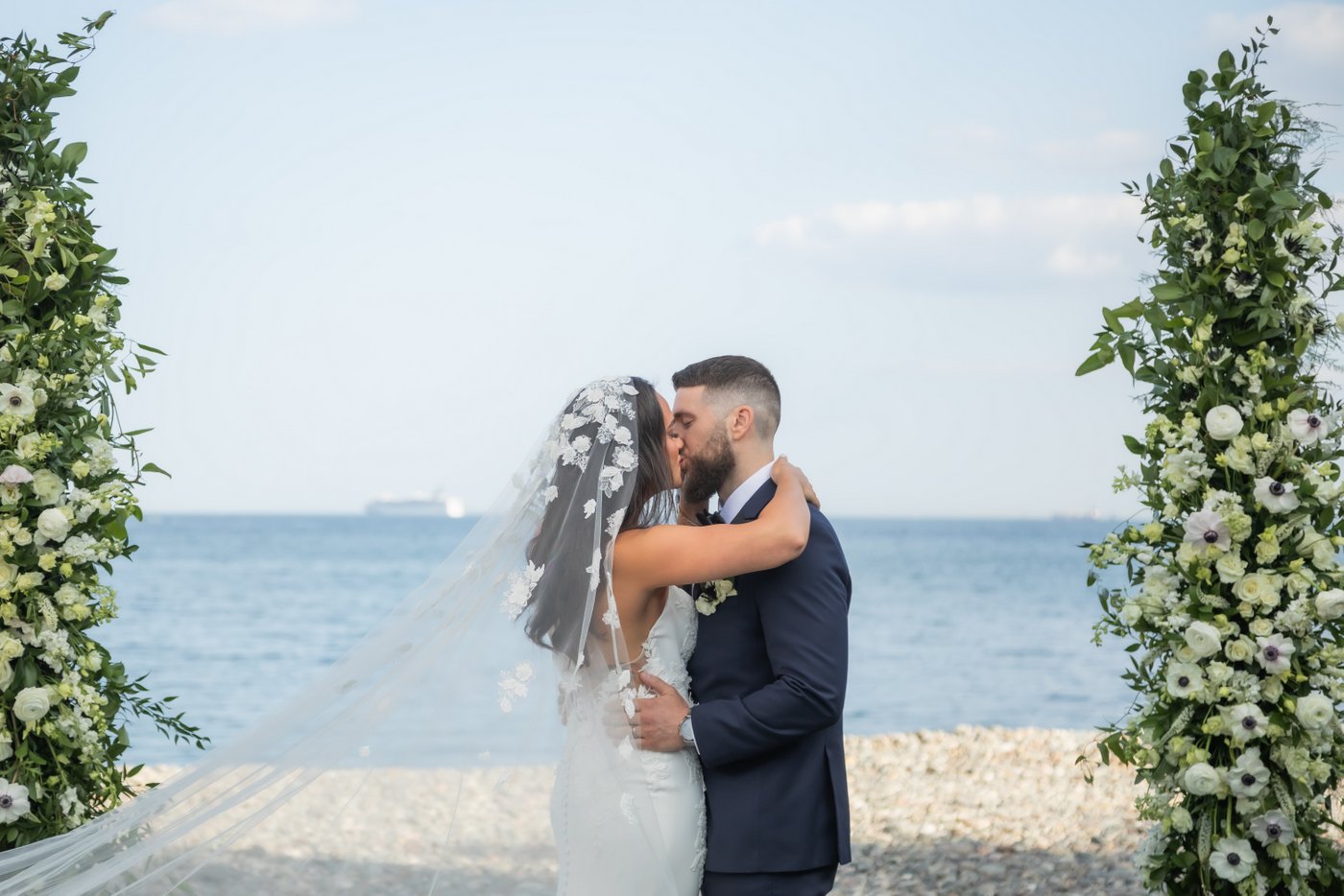 The newlywed couple shares their first kiss during their waterfront wedding ceremony at Oceanview of Nahant.