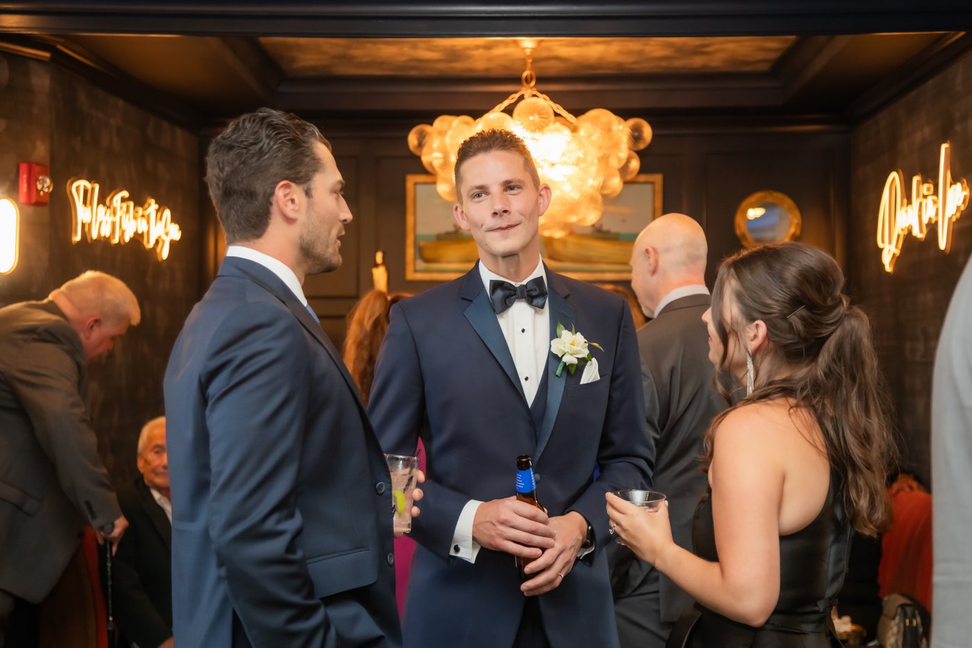 Guests chatting in the bar room during cocktail hour at the Oceanview of Nahant wedding in the north shore