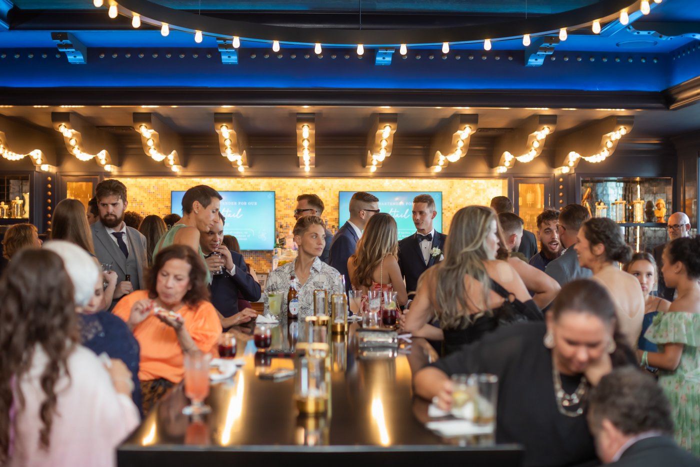A wide shot of the wedding guests in the bar area during cocktail hour at Oceanview of Nahant