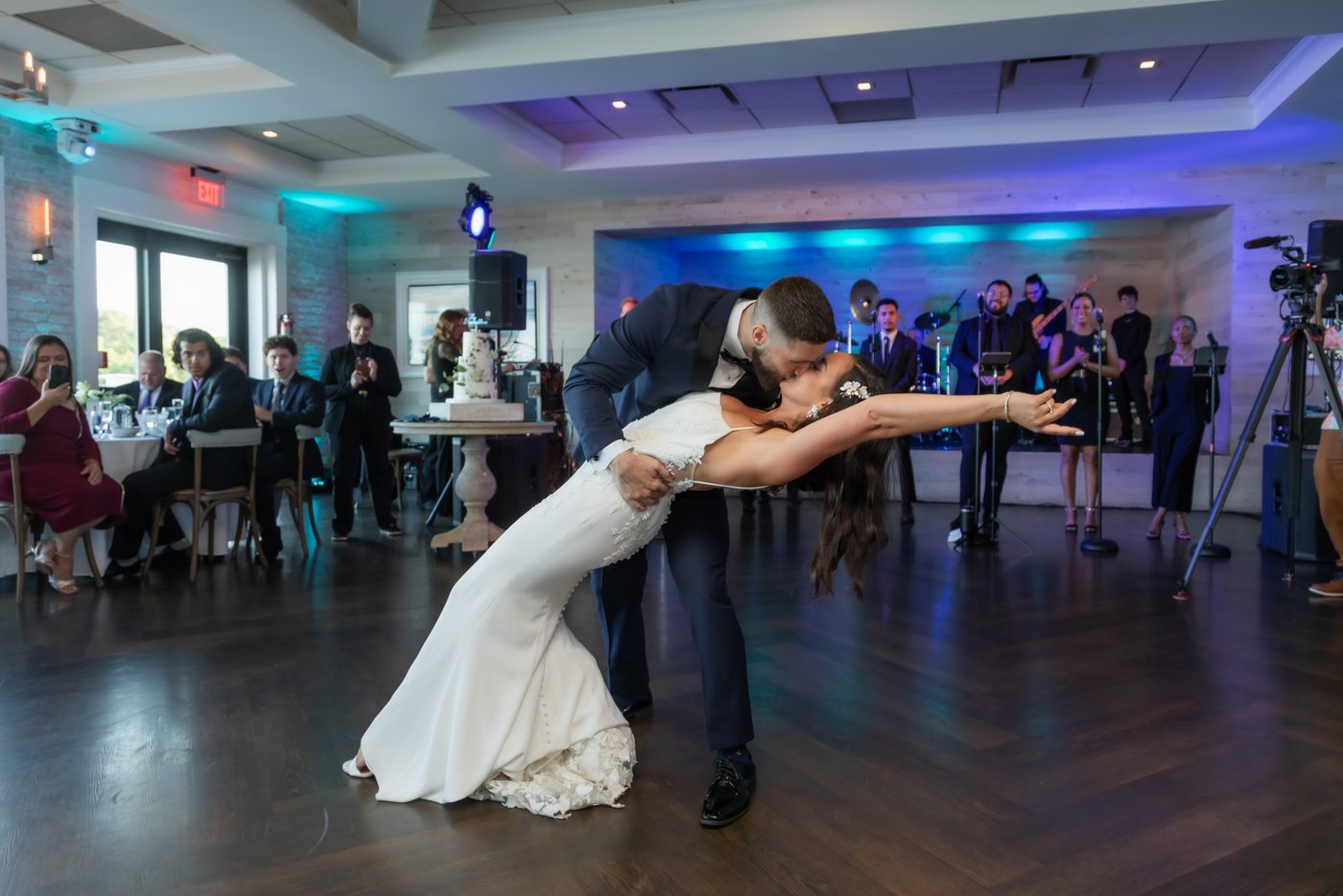 Groom dips bride during their romantic first dance at a lively wedding reception at on the North Shore of Massachusetts.
