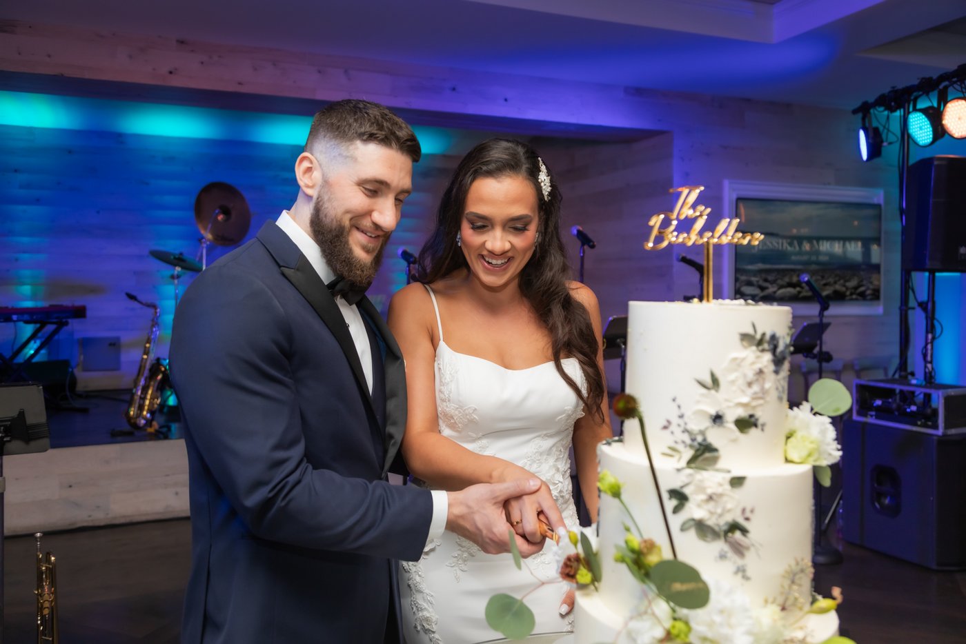 The bride and groom cut their cake at their Oceanview of Nahant wedding