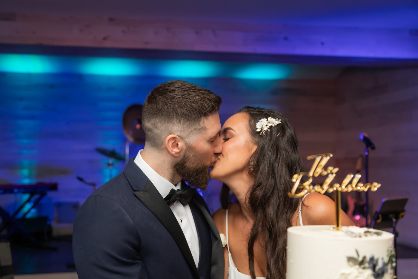 The bride and groom kiss after cutting their wedding cake