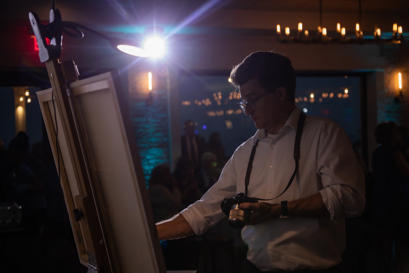 The live painter continues to paint as the reception hall lights dim