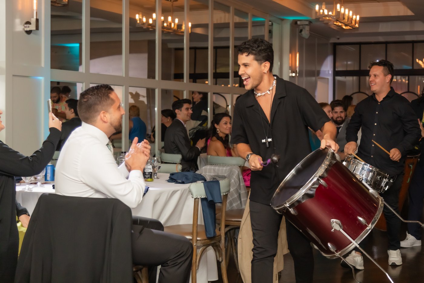 The samba drummers walk into the hall, exciting the guests