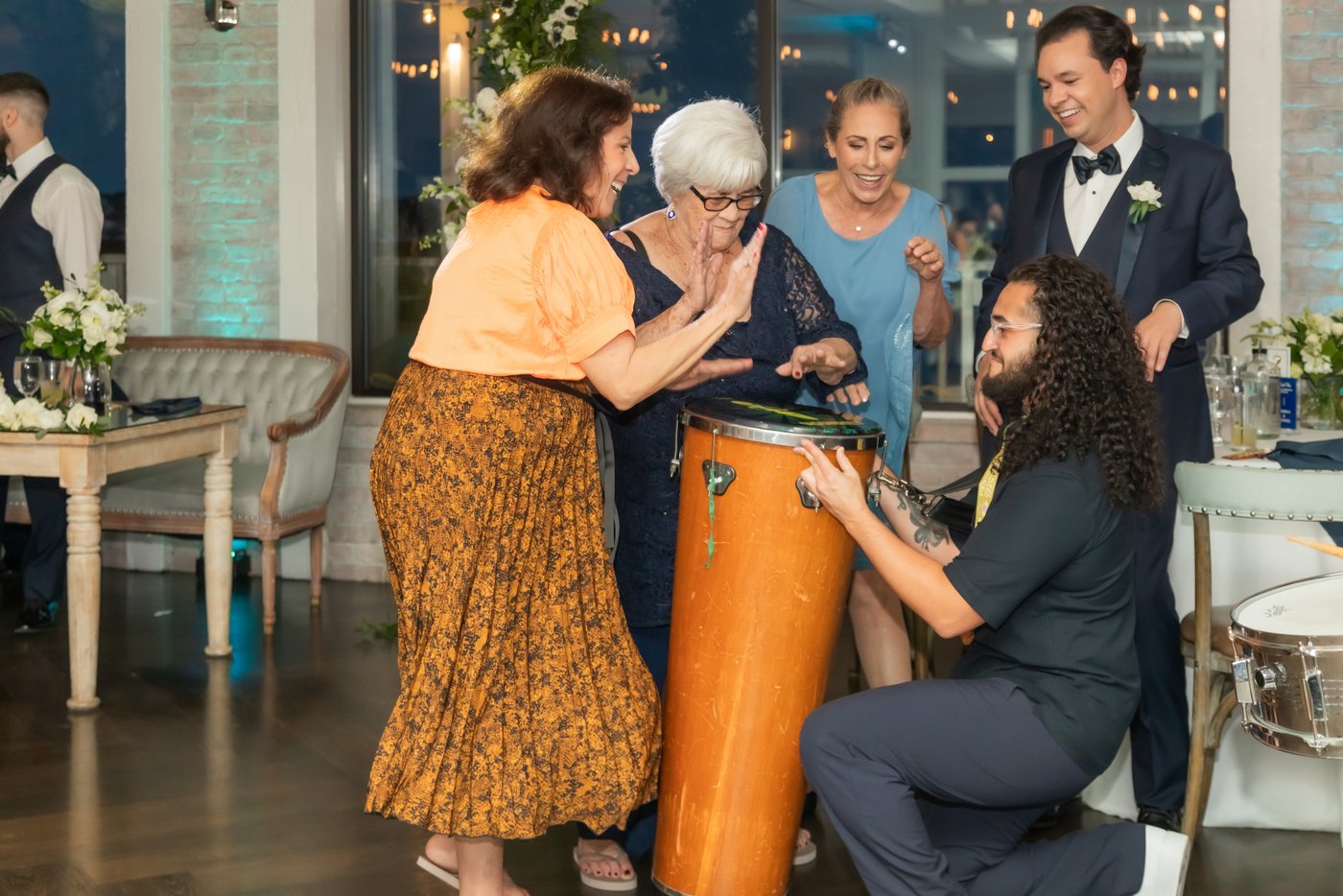 The bride's grandmother helps the samba drummers beat the drums