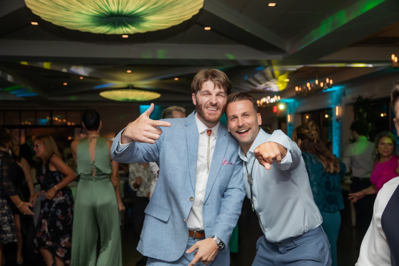 Guests pointing at the camera while posing on the dancefloor at the Oceanview of Nahant Wedding