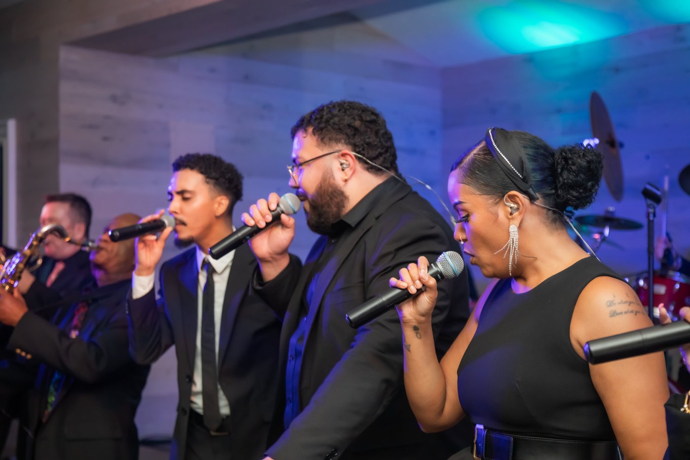 Three singers singing together during the wedding reception
