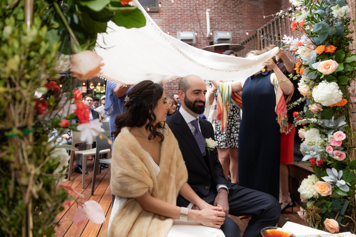 Bride and groom hold hands under the canopy at the altar during their SRV Boston wedding.