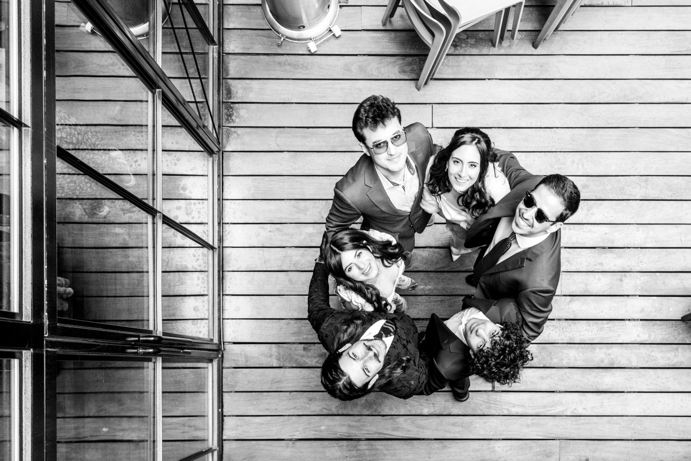 A black and white creative portrait of the bride and her wedding guests standing in a circle during an SRV Boston wedding, photographed from above by creative wedding photographers Spagnolo Photography.