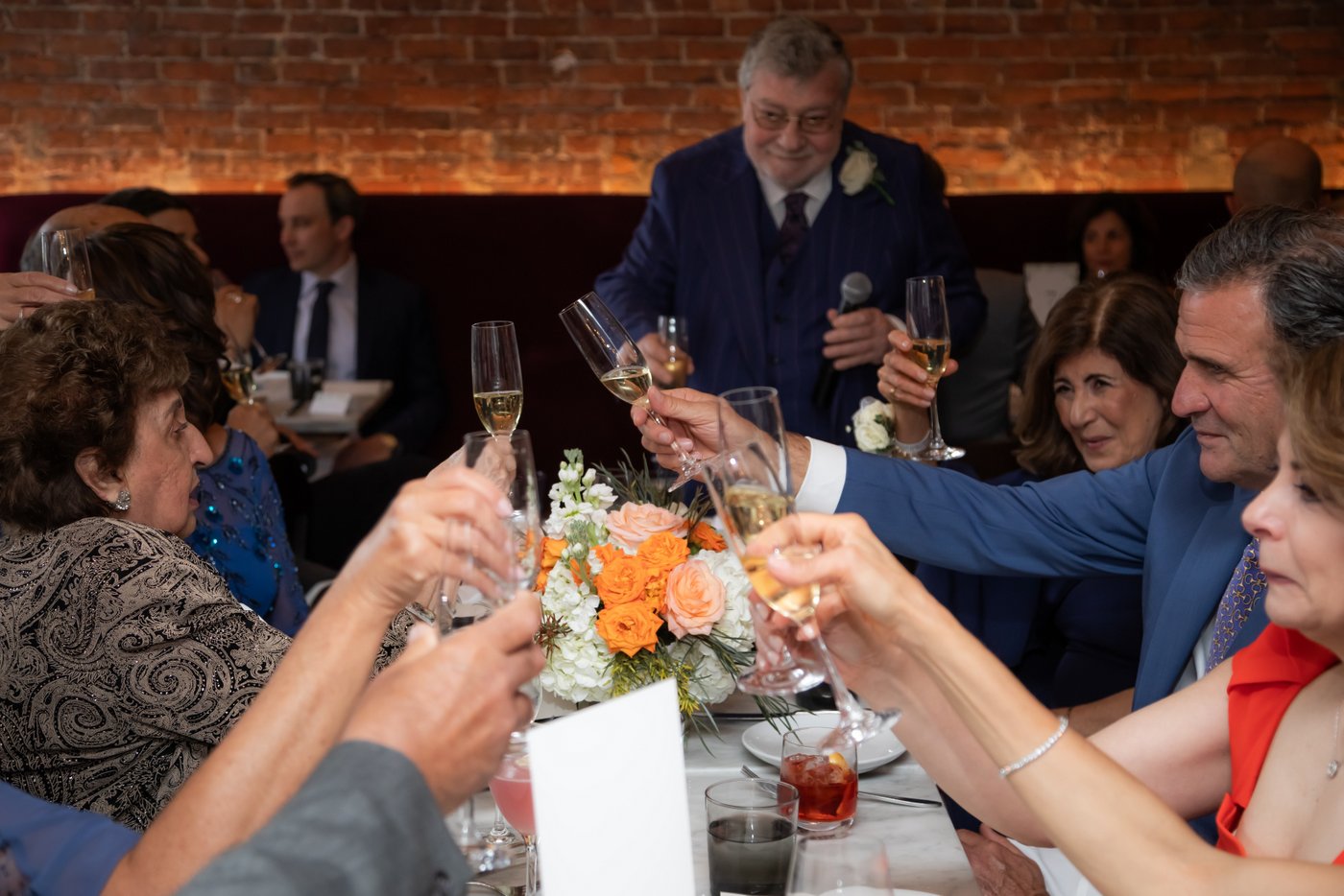 Guests clink their champagne flutes at an SRV Boston wedding reception.