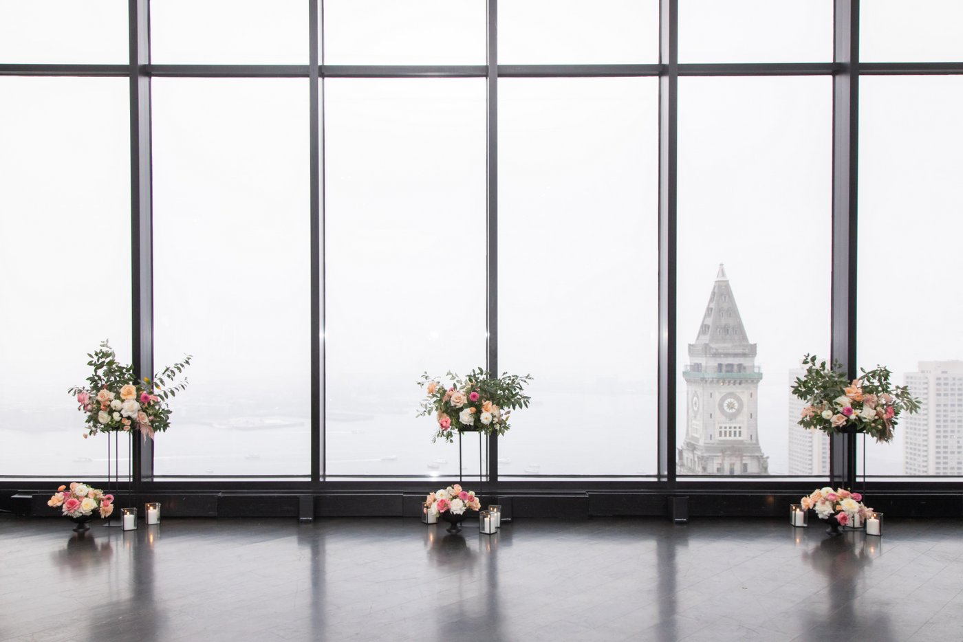 Tall wedding floral arrangements by the windows of the State Room in Boston