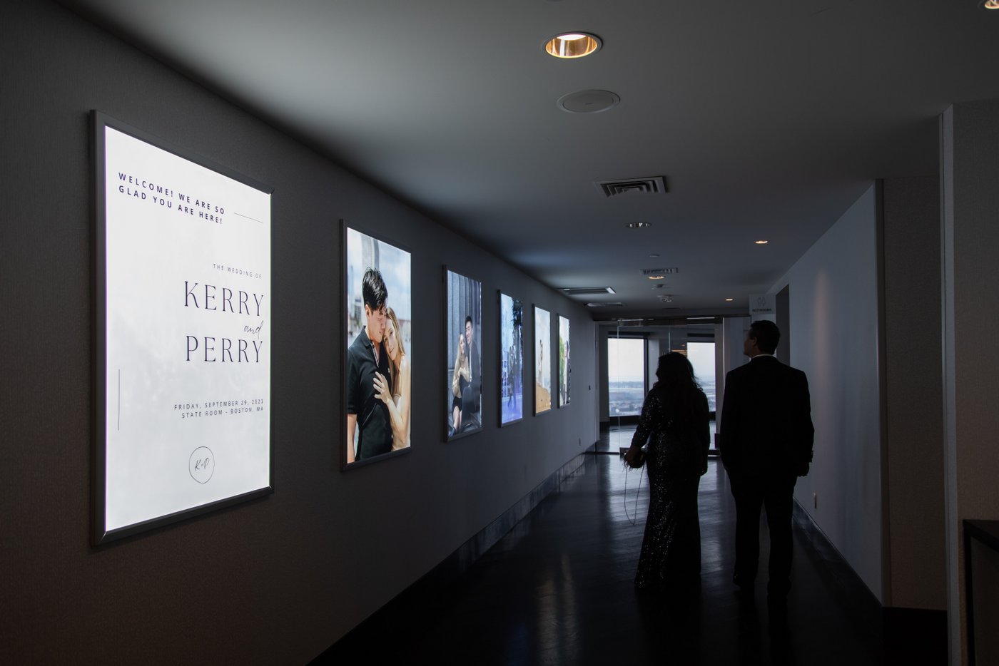 The State Room Boston hallway leading up to the Great Room decorated for a wedding with massive backlit framed photos of the bride and groom taken by their creative Boston wedding photographer Spagnolo Photography
