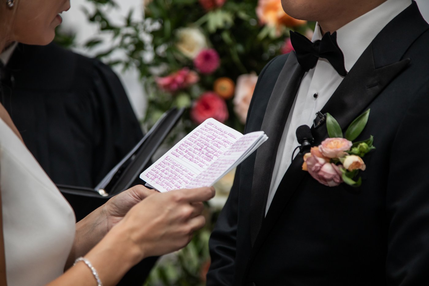 A close-up of the bride's hands holding her book of vows at a State Room Boston wedding.