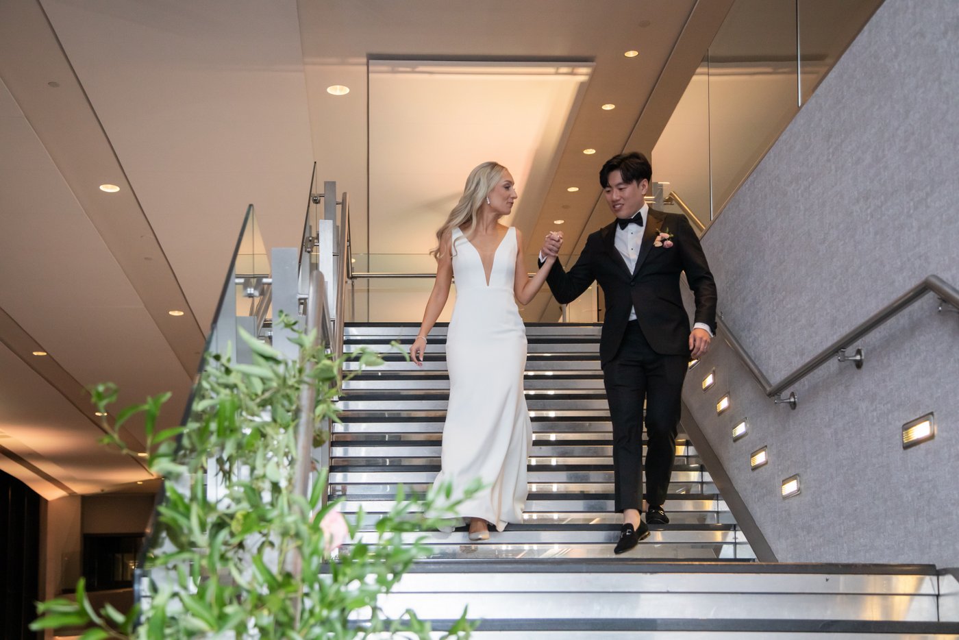 The bride and groom descend the stairs for their Grand Entrance at the State Room on their wedding day.