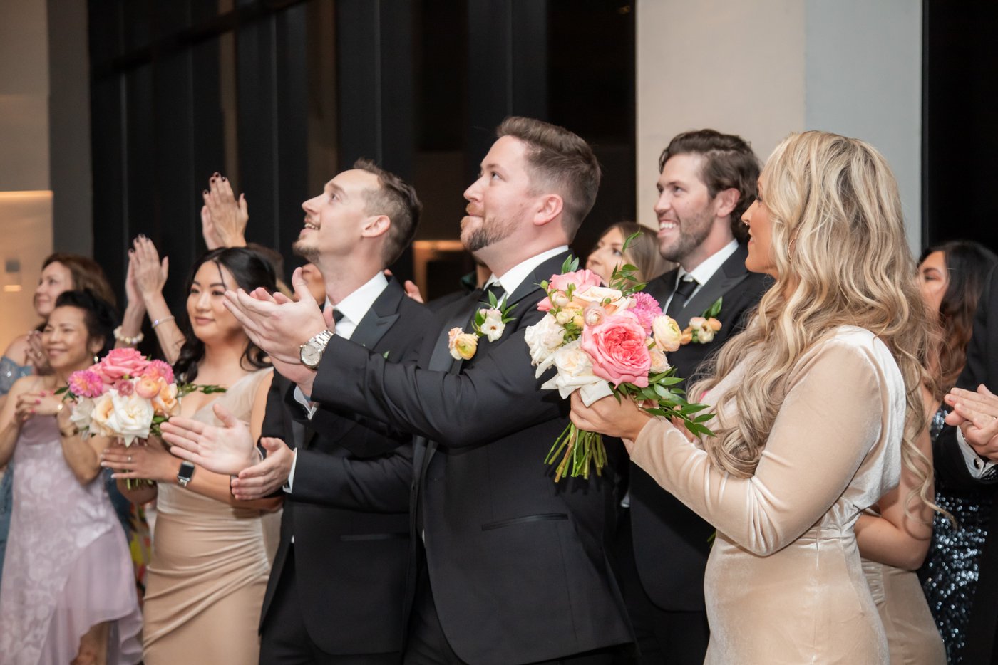 Guests clap and cheer to welcome the newlyweds into the wedding reception area at the State Room in Boston.