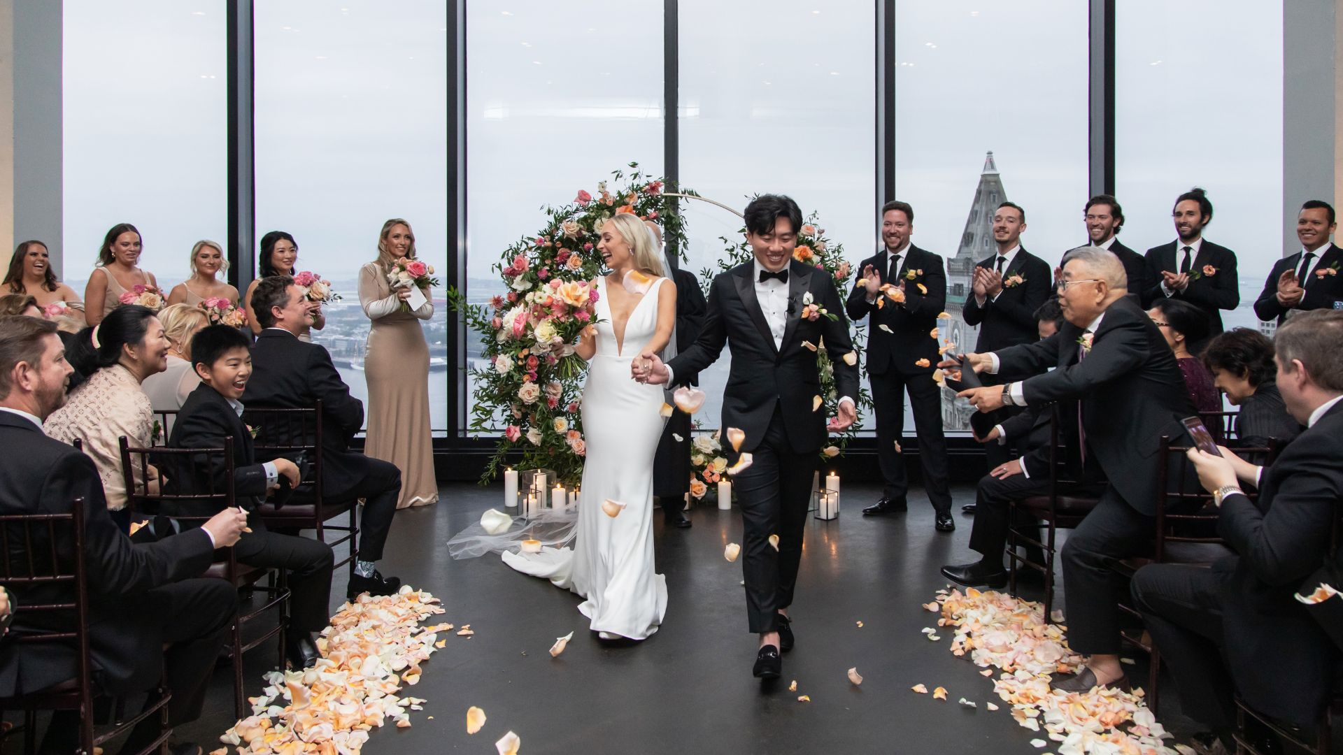 Guests throw rose petals at the bride and groom in the State Room's Great Room in Boston