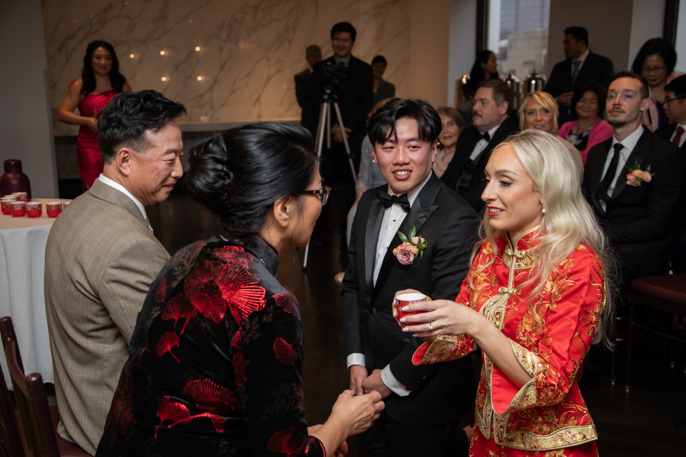 The bride and groom offering tea to relatives during a Chinese wedding tea ceremony at the State Room in Boston